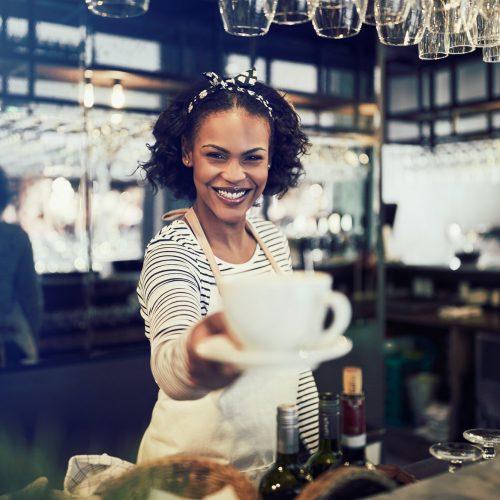 smiling-barista-holding-up-a-fresh-cup-of-coffee.jpg